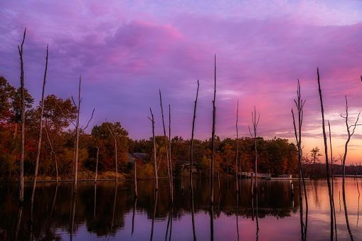 Dramatic autumn sky over lake in Manasquan Reservoir, New Jersey featuring beautiful sunrise colors