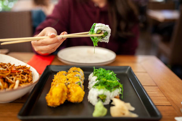 istock woman eating sushi 1062688648