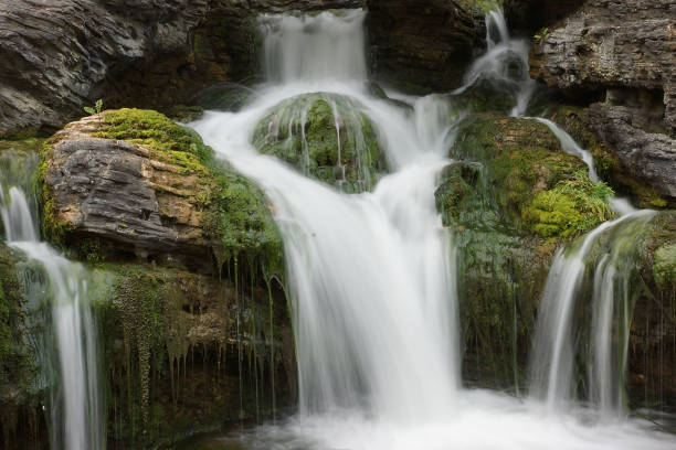 istock Long exposure waterfall over brown and green rocks shot in low key 1062690772