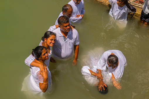 Pilgrims baptizing in the Jordan River, in the Yardenit Baptismal Site. Northern Israel.