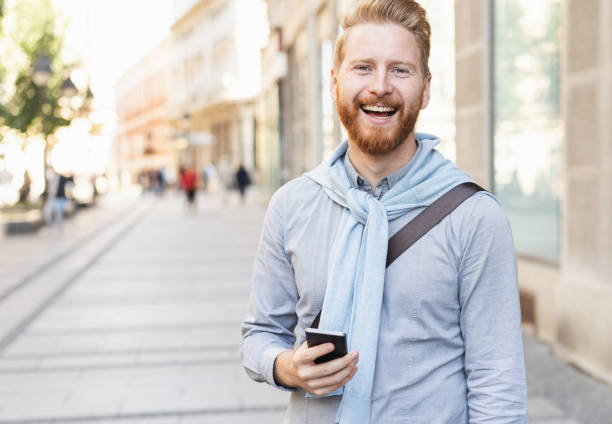 istock Smiling man texting on the street 1062693752