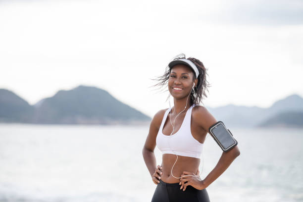 retrato de mujer joven alegre atlética con el teléfono móvil en la playa - brazil beach copacabana beach recreational pursuit fotografías e imágenes de stock