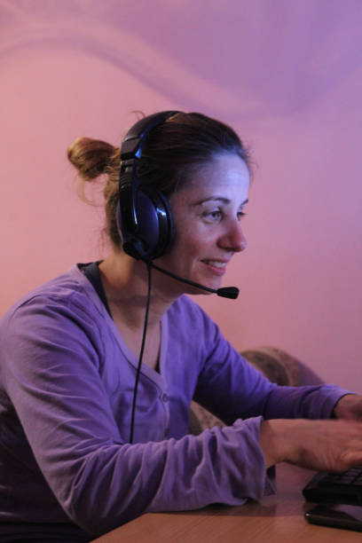 istock Woman on computer with headphones play game 1062702758