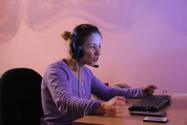 istock Woman on computer with headphones play game 1062702952