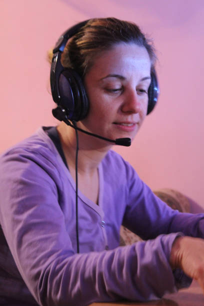 istock Woman on computer with headphones play game 1062703070
