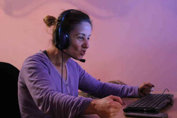 istock Woman on computer with headphones play game 1062703254