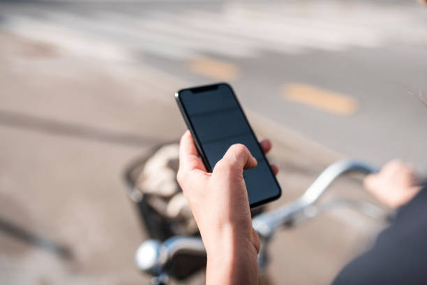 istock Young woman using a smart phone and walking with a bicycle 1062724418