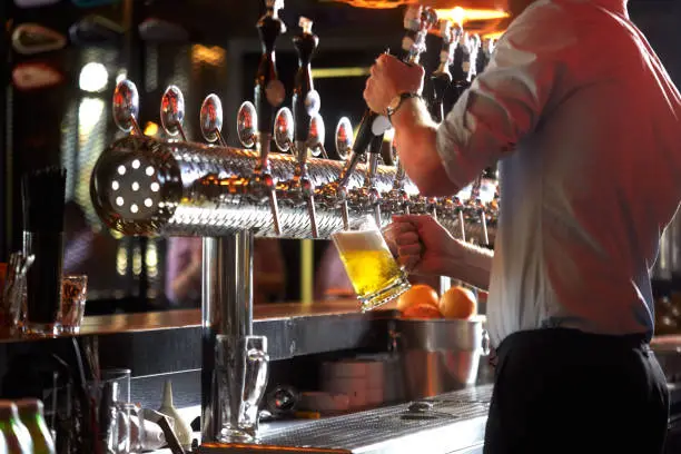 Photo of Barista pouring beer into glass