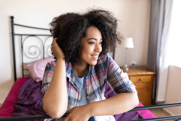 istock Smiling woman leaning on bed at home 1062738682