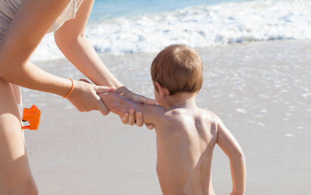istock Mother applying sunblock cream to her little son on back 1062749096