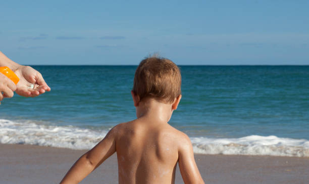 istock Mother applying sunblock cream to her little son on back 1062749098
