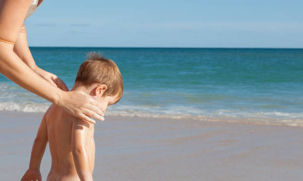 istock Mother applying sunblock cream to her little son on back 1062749100