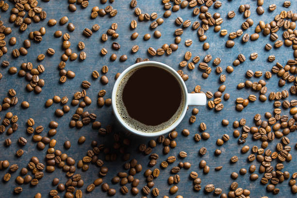 Coffee cup and beans  on black rustic vintage table. Coffee concept background.