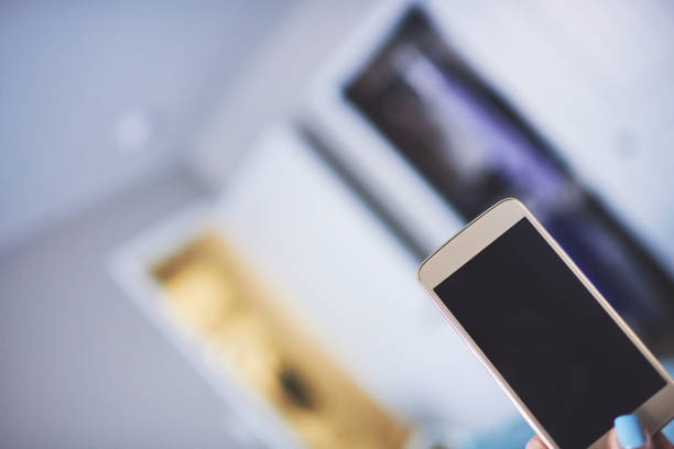 Female hand holding smartphone in indoor setting