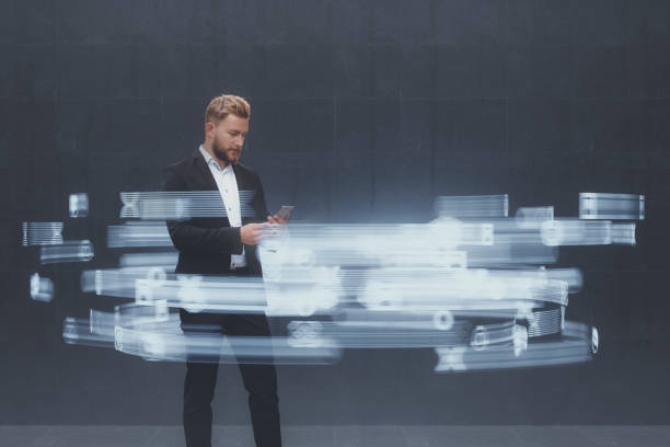 Businessman text messaging with flowing hologram icons
