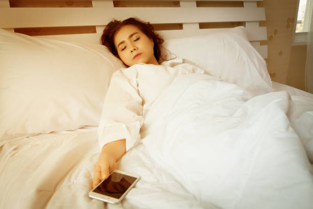 istock Young beautiful woman sleeping with smartphone in bedroom 1062766532