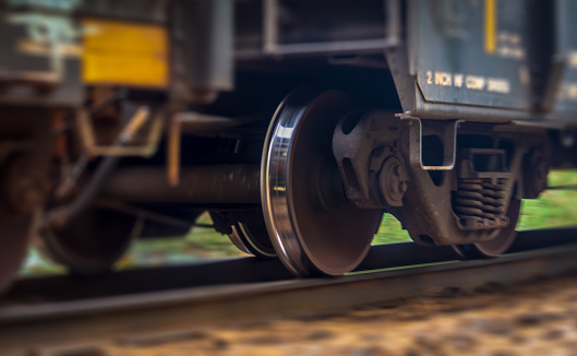 A close up view of a trains wheel in motion as it speeds past