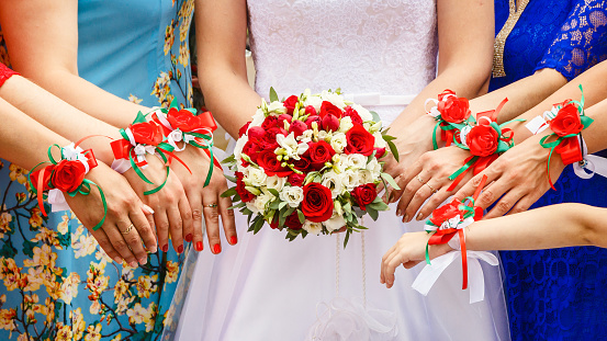 bridesmaids are drawn to bouquet, the same red armbands on the arms of the bridesmaids