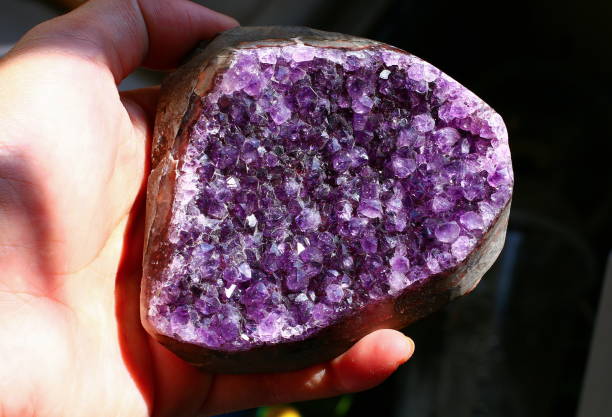 рука проведения аметист кристалл фиолетовый кварцевый камень драгоценный камень geode - chakra crystal recovery spirituality стоковые фото и изображения