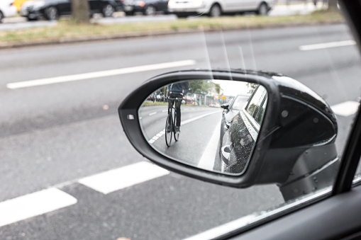 Cyclist in the exterior mirror of a car