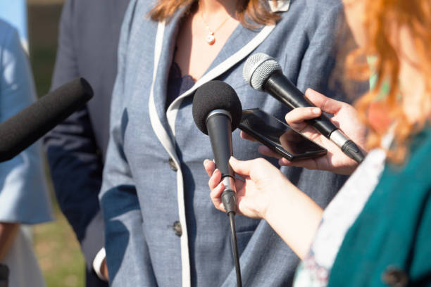 Journalists making media interview with businesswoman or female politician stock photo