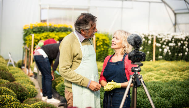 istock Senior couple vlogging in greehouse 1062830976