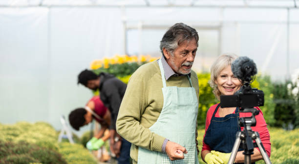 istock Senior couple vlogging in greehouse 1062831044