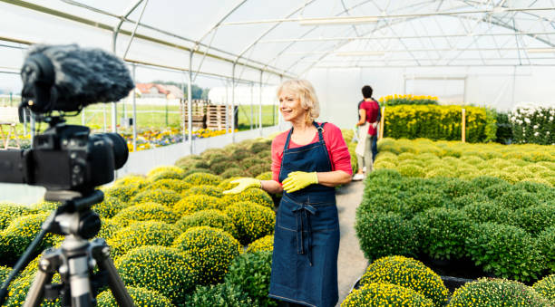 istock Senior woman vlogging in greehouse 1062831064