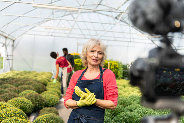 istock Senior woman vlogging in greehouse 1062831066