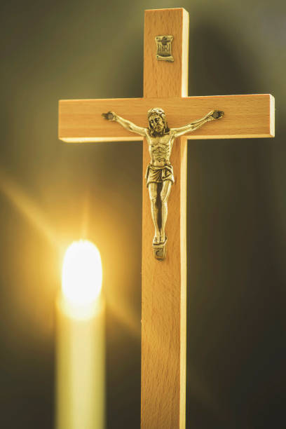 istock Wooden cross with lit candles on a bright background 1062835278