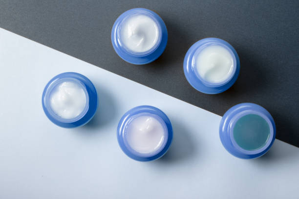 un conjunto de cinco frascos azul con cremas hidratantes para el uso día y noche. cosméticos de los hombres para el cuidado de la piel. - lightener fotografías e imágenes de stock