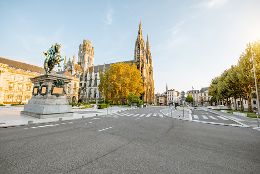 Street view with Napoleon monument and church of saint-Ouen during the sunset in Rouen city, France