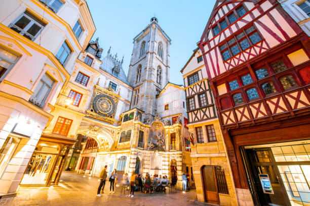 Night view of the old town in Rouen city, France Street view with illuminated buildings and famous clock tower during the twilight in the old town of Rouen city in France rue du gros horloge photos stock pictures, royalty-free photos & images