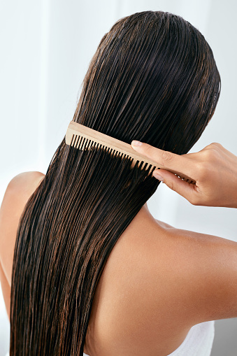 Cuidado del cabello. Hermosa mujer cepillado cabello largo mojado después del baño photo