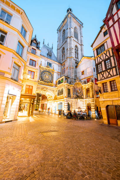 Night view of the old town in Rouen city, France Street view with illuminated buildings and famous clock tower during the twilight in the old town of Rouen city in France rue du gros horloge photos stock pictures, royalty-free photos & images