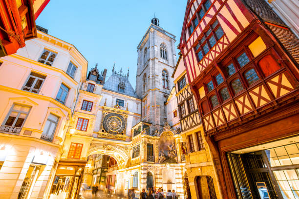 Night view of the old town in Rouen city, France Street view with illuminated buildings and famous clock tower during the twilight in the old town of Rouen city in France rue du gros horloge photos stock pictures, royalty-free photos & images