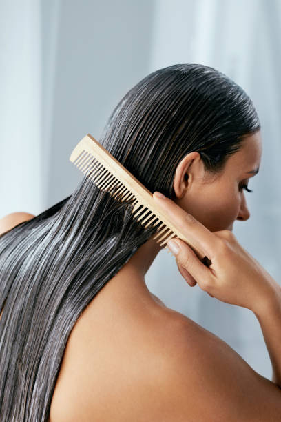 tratamiento del cabello. mujer con máscara en primer plano sobre el cabello húmedo - peine fotografías e imágenes de stock