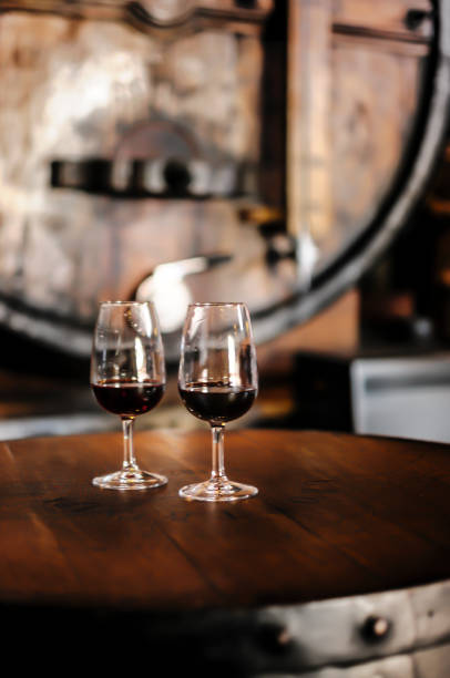 Glasses containing tawny and ruby Porto wine Tasting wine in wineyard restaurant in Porto with atmospheric background. Glasses standing on a barrel table. tawny stock pictures, royalty-free photos & images