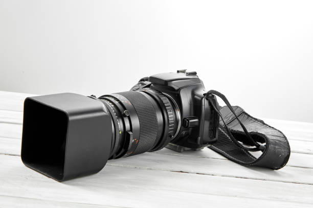 istock BLACK DSLR Camera on white wooden background 1062843648