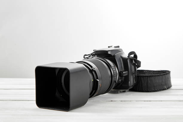 istock BLACK DSLR Camera on white wooden background 1062843654
