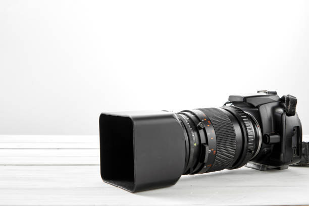 istock BLACK DSLR Camera on white wooden background 1062843674