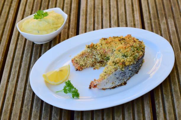 istock Baked salmon with herb crust, served with mashed potato, lemon and parsley 1062847574