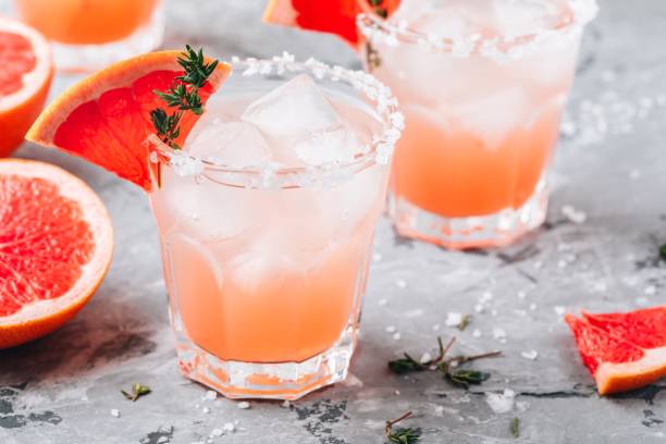 Grapefruit salty dog Cocktail Grapefruit salty dog Cocktail with ice in glass on gray stone background tequila drink stock pictures, royalty-free photos & images