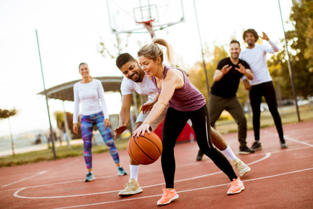 grupo de jovens multirracial jogando basquete ao ar livre - women sporting sport building exterior - fotografias e filmes do acervo