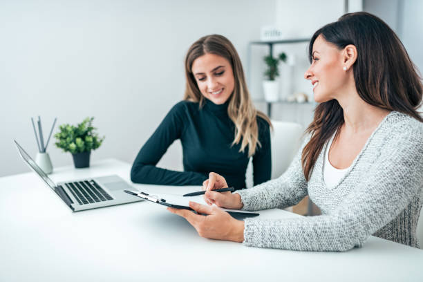 istock Two beautiful business women working together in a bright modern office. 1062863778