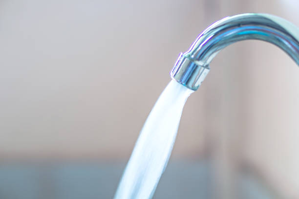 close up water running from faucet, water conservation concept