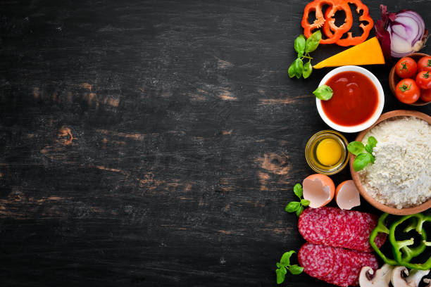 istock Ingredients for making pizza. On a wooden background. Top view. Free space for your text. 1062881404