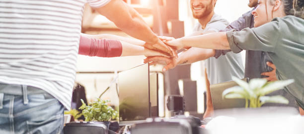 Young teamwork stacking hands together for new startup in creative office - Happy students empowering each others - Focus on hands - Co-working, marketing, digital job, business and technology concept