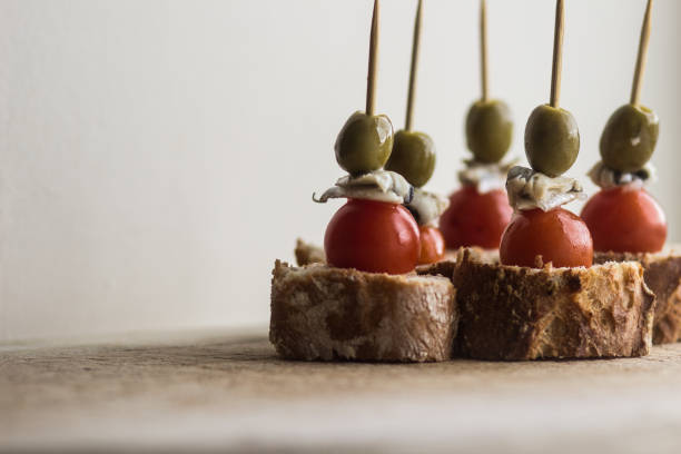 pintxo с оливковым, анчоусы, перец джильда на хлеб - amuse bouche стоковые фото и изоб�ражения