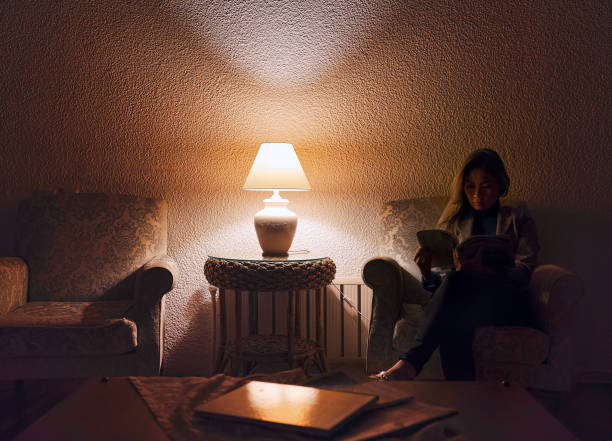istock Woman reading book in hotel lobby at night with low light 1062889738